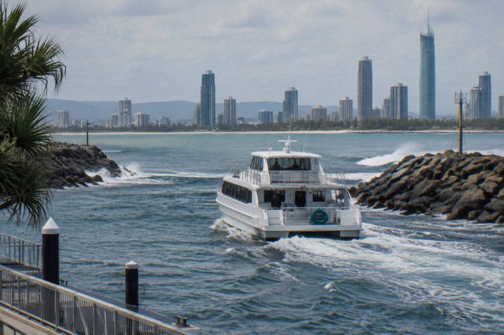 A whale watching vessel crossing calm water near the Gold Coast Seaway entrance