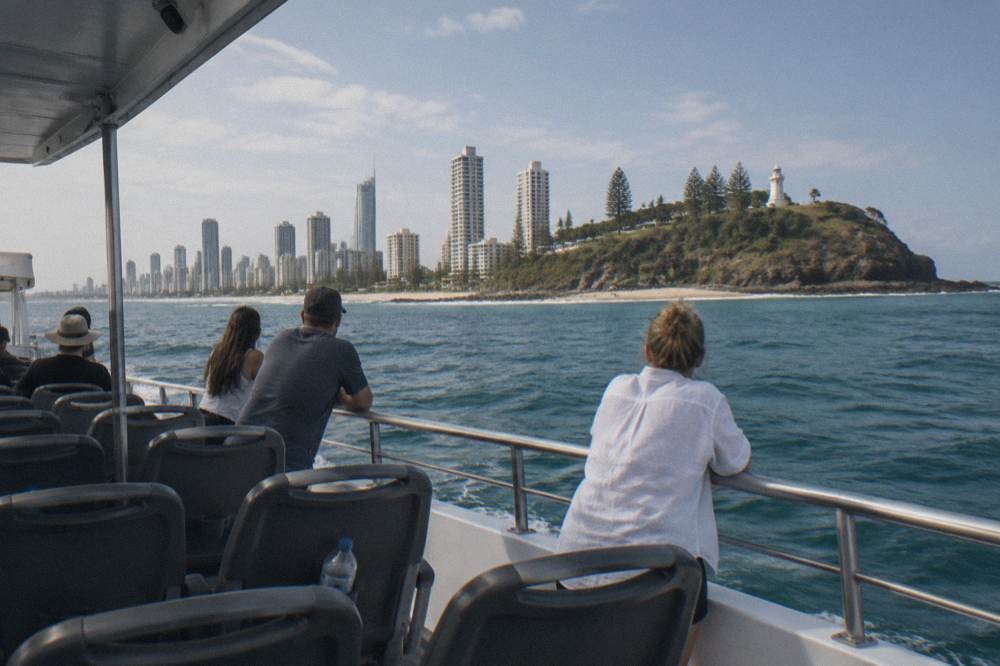 Passenger decks of a whale watching catamaran with the Gold Coast skyline behind