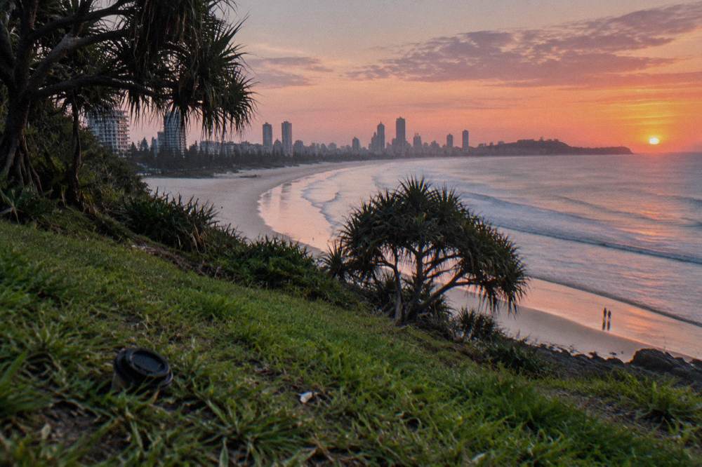 A coastal headland lookout above a long sandy beach at sunrise