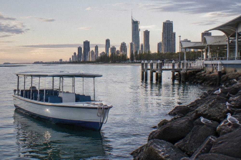 Small tour boat on calm water near a breakwall