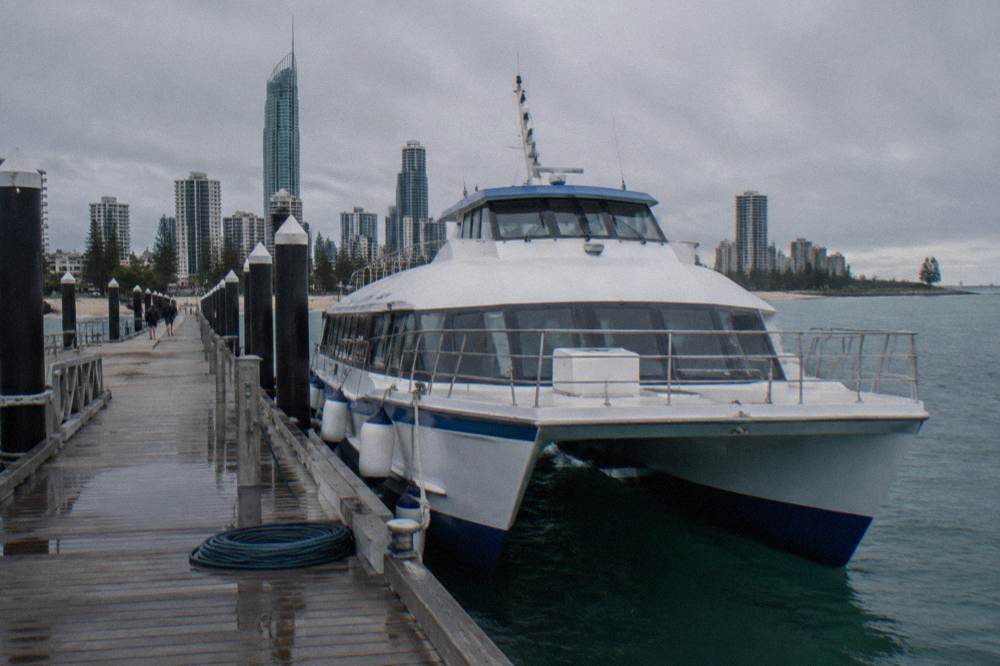 A whale watching boat at a marina berth under a grey sky before departure