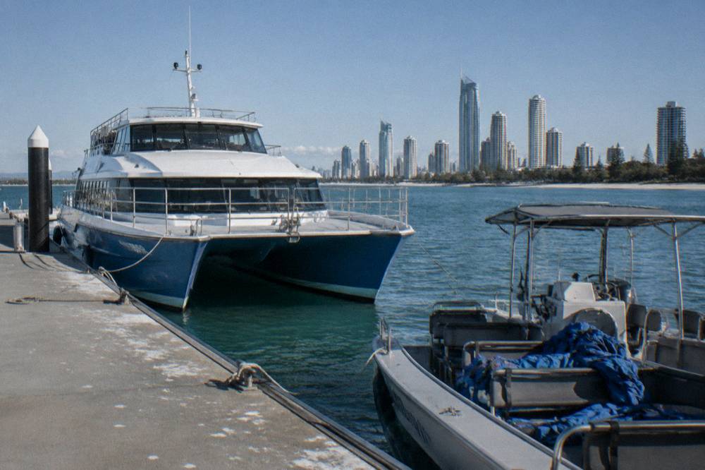 A large catamaran and a small open boat moored near each other at a marina