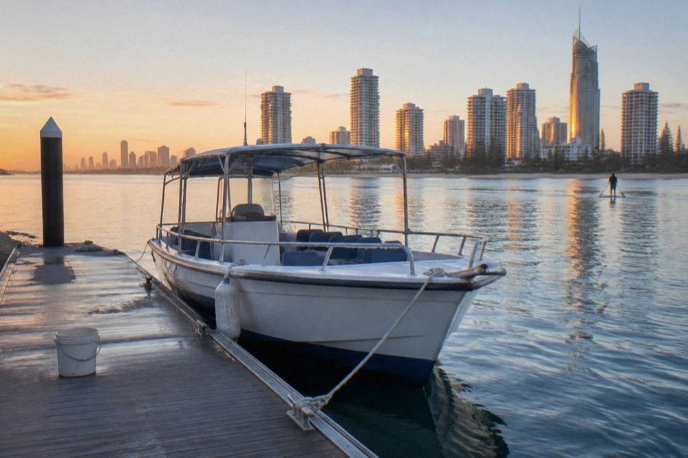 A small whale watching boat at a marina pontoon in early morning light