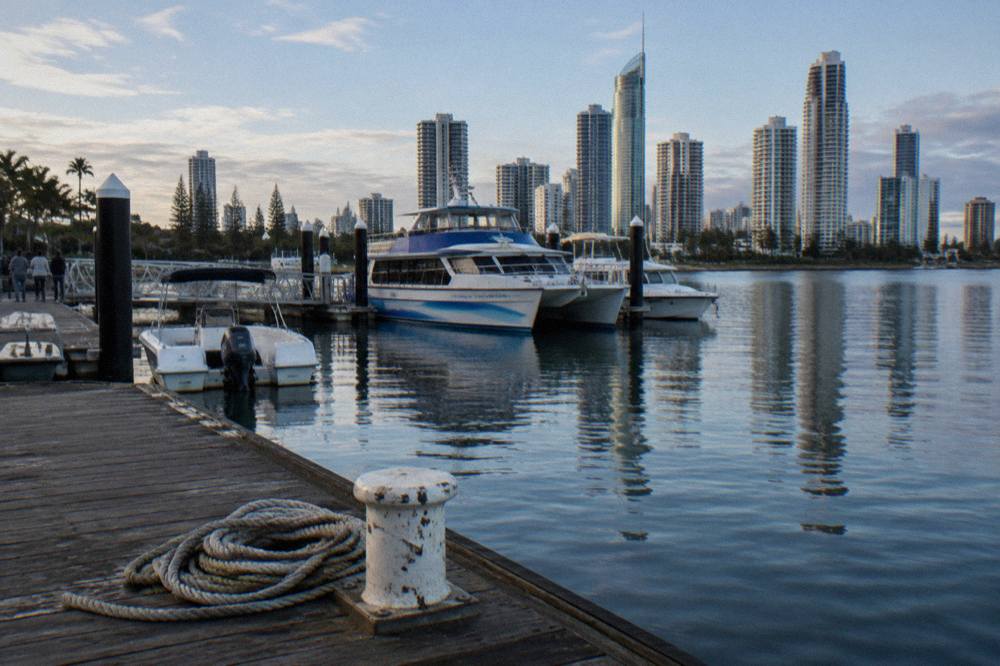 Broadwater marina with moored boats and high-rise buildings behind