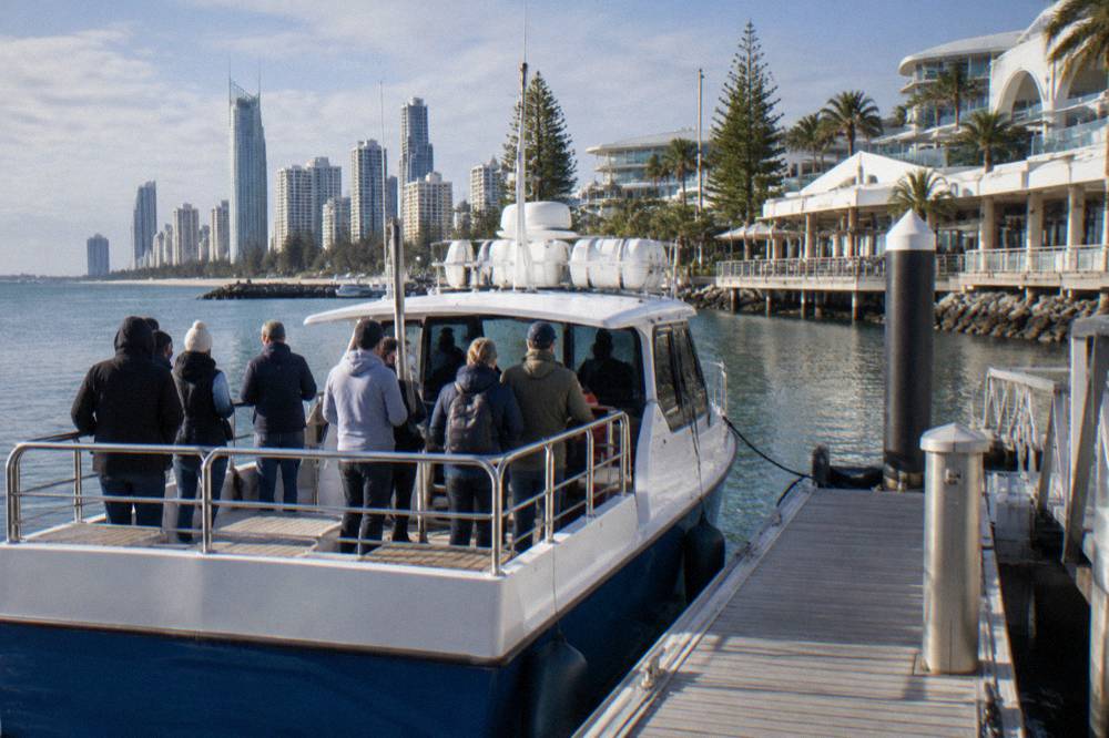 Whale watching boat at a marina berth with passengers along the rail