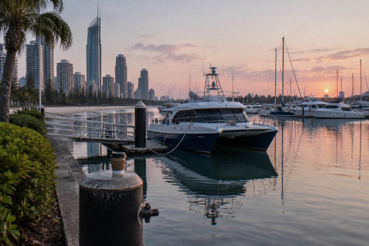 A whale watching boat moored at a marina jetty on a calm morning